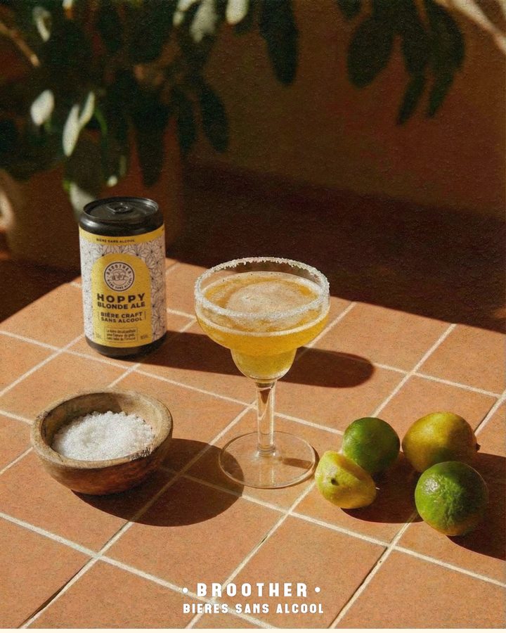 Canette BROOTHER Hoppy Blonde Ale servie façon cocktail avec sel et citrons verts sur carrelage terracotta — bière blonde sans alcool