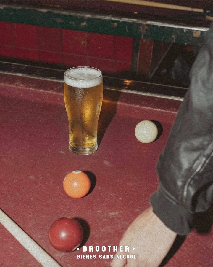 Verre de bière blonde BROOTHER au-dessus d'une table de billard rouge — bière sans alcool au bar