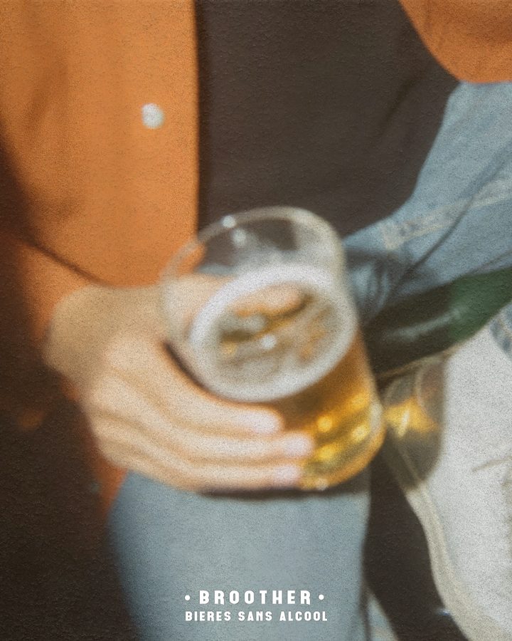Verre de bière BROOTHER à la main lors d'une soirée entre amis — bière sans alcool